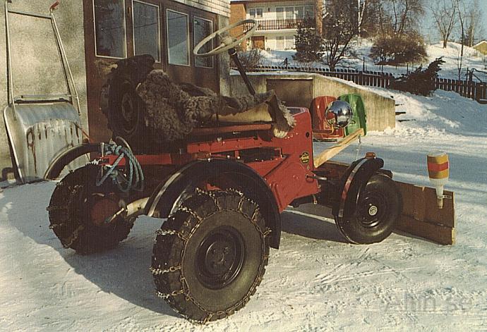 Traktor med snöplog.jpg - När jag har snökedjor med dubbar drar traktorn bra.